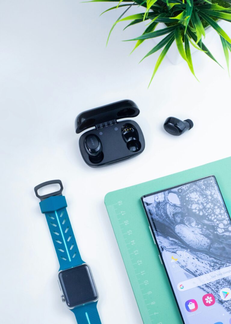 A flat lay of 2026 tech gadgets including a smartwatch, wireless earbuds, and a smart speaker.